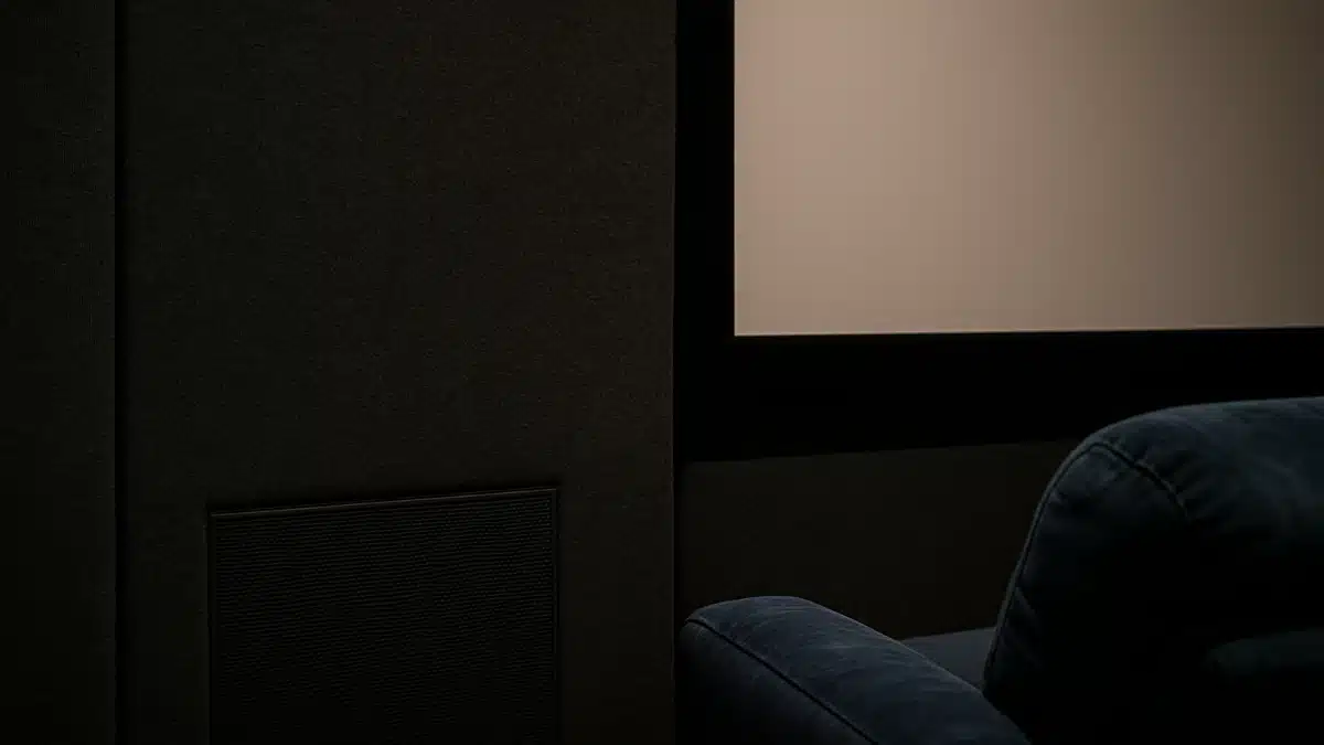 Parete di una sala home cinema con rivestimento acustico scuro, che assorbe luce e riflessioni sonore